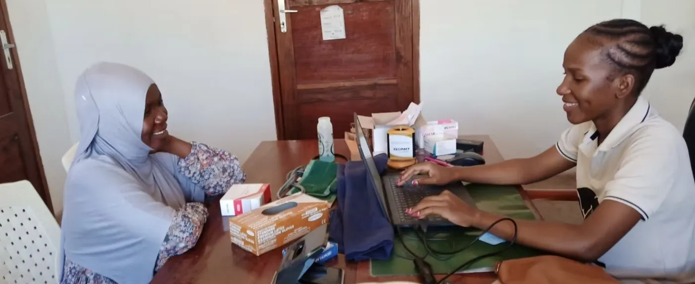 A staff member registering a smiling patient on the computer