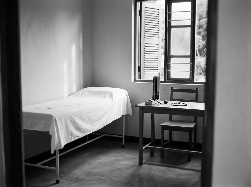 A consultation room with an examination couch and desk